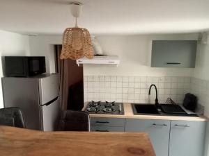 a kitchen with a stove and a refrigerator at Villa René in Lacanau
