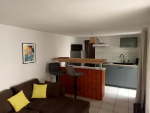 a living room with a couch and a kitchen at Villa René in Lacanau
