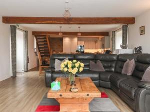 a living room with a black leather couch and a coffee table at Ploughman's Rigg in Harrogate