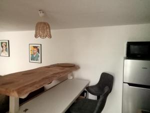 a dining room with a table and a refrigerator at Villa René in Lacanau