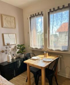 a dining room with a wooden table and chairs at Le Minimaliste Chic in Montbrison
