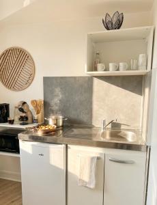a kitchen with a sink and a counter top at Le Minimaliste Chic in Montbrison