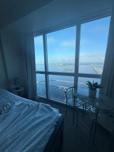 a bedroom with a bed and a table and a large window at Luxury II in Fort Myers +17 photos
