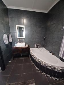 a large bathroom with a tub and a sink at Duncan Garden Cottage in Brakpan +11 photos