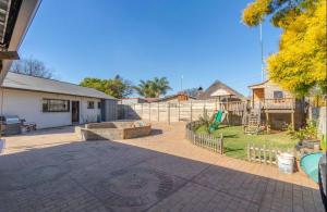 a backyard with a playground and a house at Duncan Garden Cottage in Brakpan