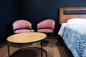 a bedroom with two chairs and a table and a bed at Apart Hotel Castellon 176 in Concepción