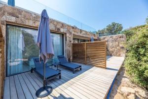 a patio with an umbrella and two chairs and a table at Hotel Monte Sereno in Zonza +7 photos