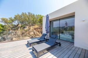two chairs and an umbrella on a deck at Hotel Monte Sereno in Zonza