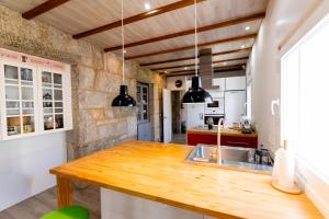 a kitchen with a wooden counter top and a sink at Casa Bubela- Vía de la plata in Dozón +15 photos