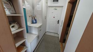 a small bathroom with white cabinets and a door at Maslačak, dvosobni in Banja Koviljača