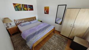 a bedroom with a bed and a dresser and a mirror at Maslačak, dvosobni in Banja Koviljača