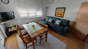 a living room with a table and a couch at Maslačak, dvosobni in Banja Koviljača