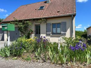 a small house with flowers in front of it at Aux Forts Champs in Vouhenans +12 photos