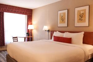 a bedroom with a large white bed with a red pillow at Marmot Lodge Jasper in Jasper