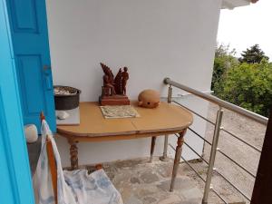 a small table on a porch with a railing at Mama's home in Arethousa