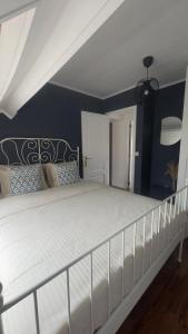 a bedroom with a white bed with blue walls at Countryside house by Pairi Daiza in Silly +5 photos