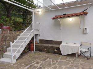 a staircase leading up to a white wall with a table and a table at Mama's home in Arethousa +11 photos