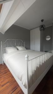 a bedroom with a white bed with a white headboard at Countryside house by Pairi Daiza in Silly