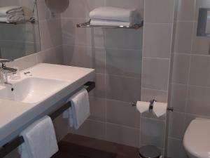 a bathroom with a sink and a toilet at Mercure Dinan Port Le Jerzual in Dinan +181 photos