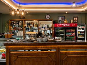 a bar with a coca cola refrigerator and a counter at Lindi Premium Hotel in Prizren