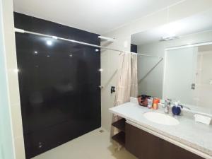 a bathroom with a shower and a sink and a mirror at Mi casa, moderna B in Vila El Carmen