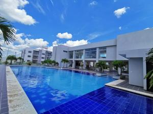a large swimming pool in front of a building at Mi casa, moderna B in Vila El Carmen
