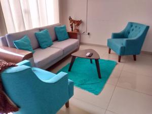 a living room with a couch and two chairs at Mi casa, moderna B in Vila El Carmen