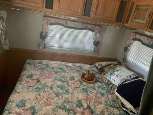 a bed in a small room with a flower patterned comforter at Sequoia National Forest Glamping in Posey