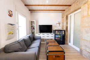 a living room with a couch and a tv at Casa Bubela, O Castro de Dozón. in Dozón