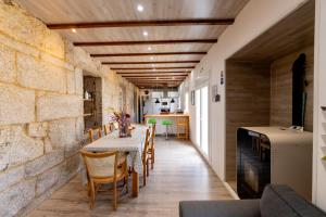 a kitchen and dining room with a table and chairs at Casa Bubela, O Castro de Dozón. in Dozón