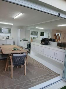 a large kitchen with a wooden table and a dining room at Hermanus Oceanbay View in Hermanus