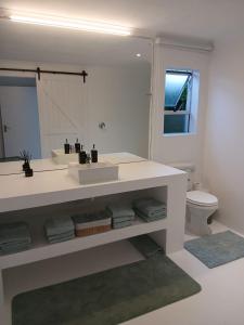 a white bathroom with a sink and a toilet at Hermanus Oceanbay View in Hermanus +33 photos