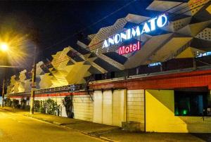 a building with a neon sign on top of it at Anonimato Hotel in Santos
