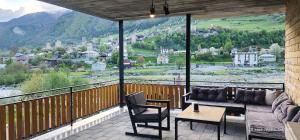a balcony with a couch and a table and chairs at hotel "Riverside Mestia" in Mestia