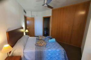 a bedroom with a bed with a blue comforter at Bella ÁGUILAS - Excelente ubicación en Las Delicias, vistas al mar, Wifi y Parking gratis in Águilas