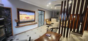 a living room with a couch and a painting on the wall at hotel "Riverside Mestia" in Mestia