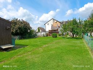 a yard with a house and a grassy field at Ferienwohnung in Espenau