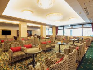 a waiting room with chairs and tables and a tv at Racine Shinmaebashi in Maebashi