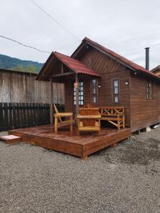 a wooden cabin with a deck with a bench at Cabana Família Lima in Urubici