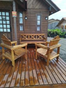 two benches sitting on a deck in front of a cabin at Cabana Família Lima in Urubici +2 photos