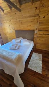 a bedroom with a bed in a wooden room at Cabana Família Lima in Urubici