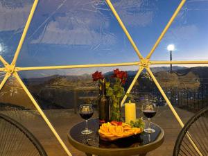 a table with two glasses of wine and flowers on it at Trichk Resort in Goris