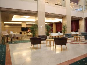 a lobby with chairs and tables in a building at Racine Shinmaebashi in Maebashi