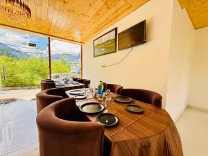 a dining room with a wooden table and chairs at Hotel Deluxe Inn Manali in Manāli