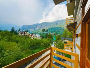 a balcony of a house with a view of a mountain at Hotel Deluxe Inn Manali in Manāli