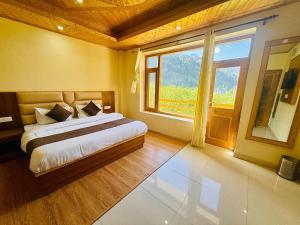 a bedroom with a bed and a large window at Hotel Deluxe Inn Manali in Manāli