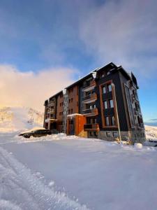 a building in the snow in the snow at Vila Golija StudiovetKop in Kopaonik