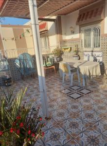 a patio with a table and chairs on a tile floor at Oumayma in Sousse