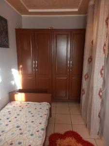 a bedroom with a bed and some wooden cabinets at Oumayma in Sousse