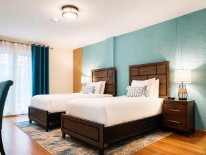 two beds in a bedroom with blue walls at Manta Lodge and Dive Centre in Speyside